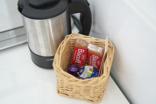 a basket filled withocolates and candy next to a coffee maker at Eco Overnight Inn - Self Check-in in Götzendorf an der Leitha