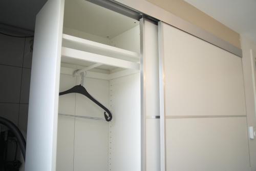 a sliding glass door in a closet with a hanger at Eco Overnight Inn - Self Check-in in Götzendorf an der Leitha