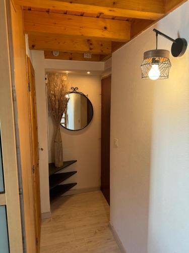 un couloir avec un miroir et un escalier dans l'établissement Perle Alpine, à Annecy