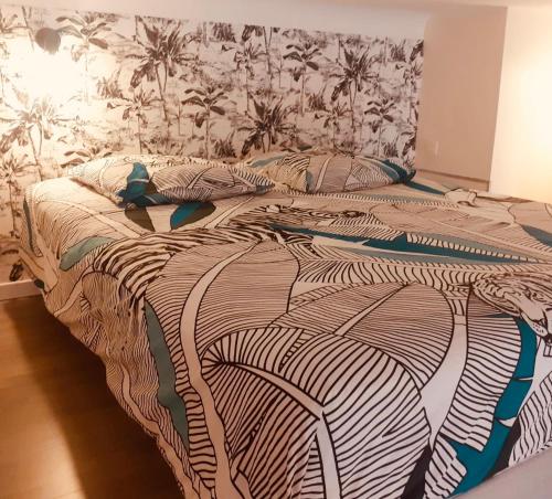 - une chambre avec un grand lit et une couette noire et blanche dans l'établissement le cosy de carole, à Cannes