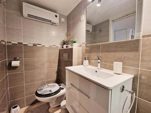 une salle de bain avec un lavabo blanc et des toilettes dans l'établissement le cosy de carole, à Cannes