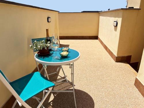 a small blue table with a blue chair and glasses at My tiny lovely house in Civitavecchia