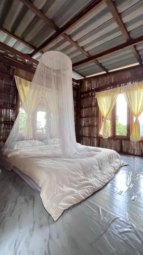 a large bed in a room with windows at Chakerpor rice terrace in Ban Mae Sapok Noi
