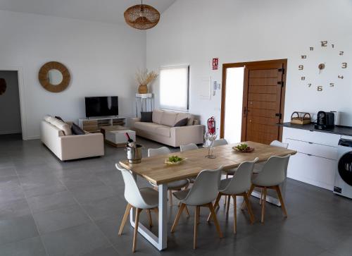 a kitchen and living room with a wooden table and chairs at Casa Rural La Yesería Alcocer in Sacedón