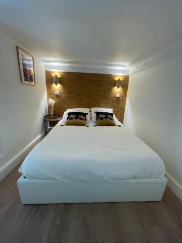 une chambre avec un grand lit blanc avec deux oreillers dans l'établissement Appartement de charme Art Déco - Hyper-centre ville - Place d'Erlon - Gare - Reims, à Reims