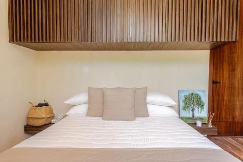 a bedroom with a large bed with white sheets at Alberca y balcon privado a 6 minutos de la playa in Tulum