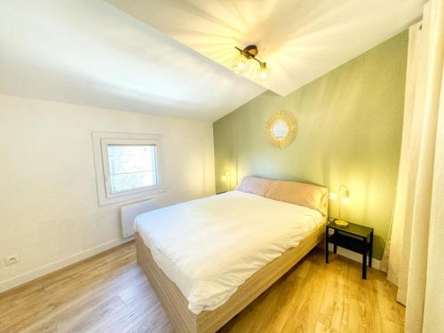 a bedroom with a bed and a ceiling fan at Le Jardin de la Cathédrale - T2 - Centre Ville - Emplacement & Vue Extraordinaires in Narbonne