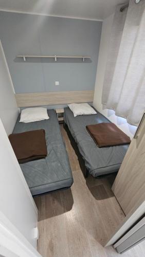 Cette petite chambre comprend 2 lits. dans l'établissement Charmant mobil-home cosy 168, à Narbonne