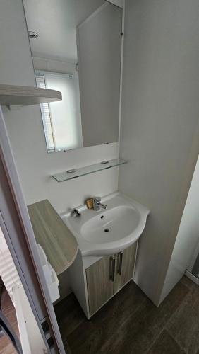 une salle de bain avec un lavabo et un miroir dans l'établissement Charmant mobil-home cosy 168, à Narbonne