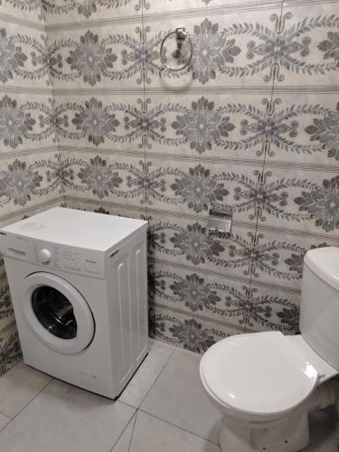 a washing machine in a bathroom with a toilet at Guest House in Garni