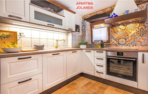 a kitchen with white cabinets and a stove at Apartma Jolanda in Šmarje