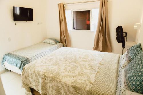 a bedroom with two beds and a television in it at Casa Bananeiras Tunel in Bananeiras