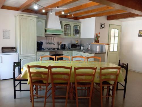 une cuisine avec une table et des chaises dans une cuisine dans l'établissement Les gîtes du chatelet, à Ferdrupt