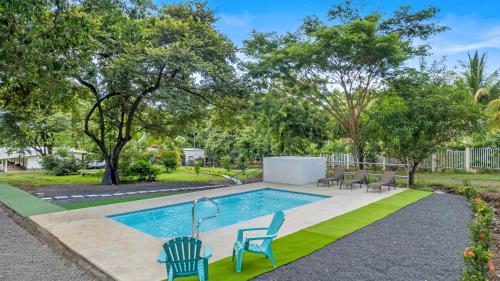 a pool with chairs and trees in a yard at Finca Brisas de la Montaña in Coco