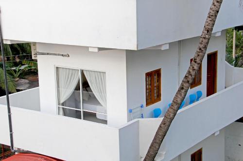 a white house with a palm tree at Bluewater Beach Resort in Trincomalee