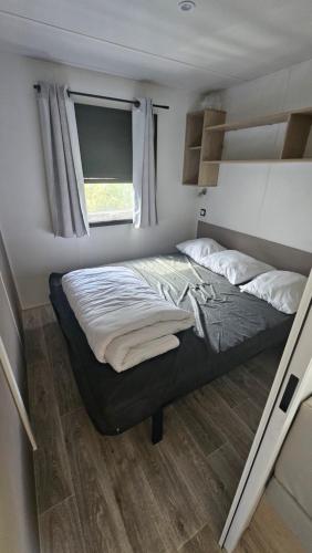 une chambre avec un lit dans une petite pièce dans l'établissement Charmant mobil-home premium 174, à Narbonne