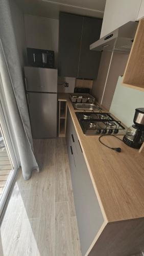 une cuisine avec une cuisinière et un réfrigérateur dans l'établissement Charmant mobil-home premium 174, à Narbonne
