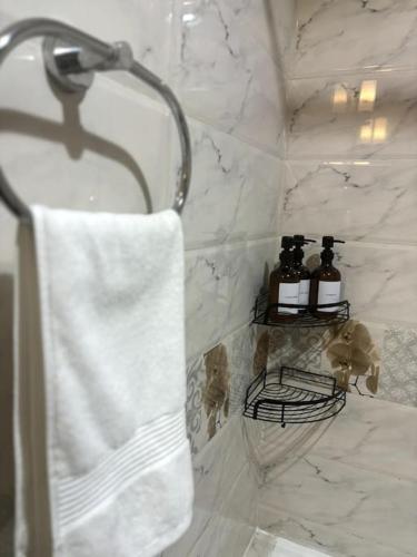 a bathroom with a shower with a white towel at Brand New Studio - Comfy & WFH in Dubai