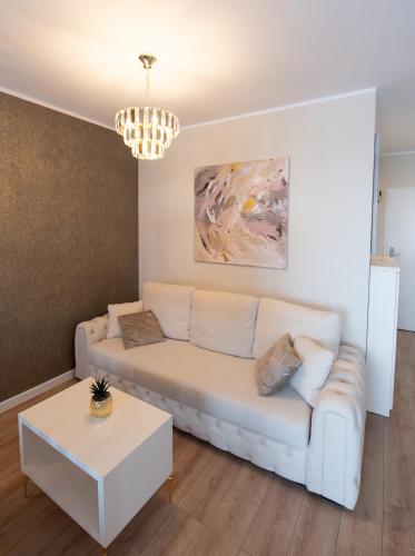 a living room with a white couch and a table at Uranus Luxury Studio Apartment in Timişoara