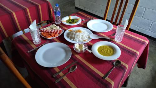 a table with plates and bowls of food on it at Villa Emerald Ella in Ella