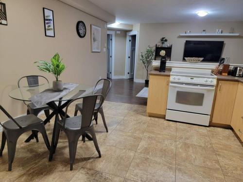 a kitchen and dining room with a table and a stove at Cozy basement in the city in Moncton