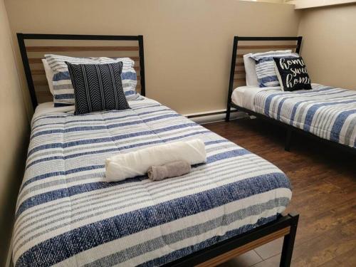 two beds sitting next to each other in a room at Cozy basement in the city in Moncton