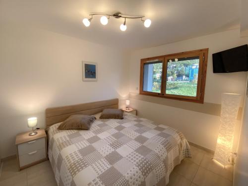 une chambre avec un lit avec deux tables de nuit et une fenêtre dans l'établissement La terrasse au bord du Lac, vue panoramique lac et montagnes , 2 ch, linge et ménage inclus, à Savines