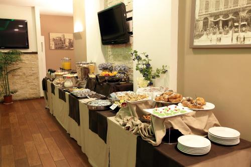a long buffet line with plates of food on it at Ibis Styles Palermo Cristal in Palermo