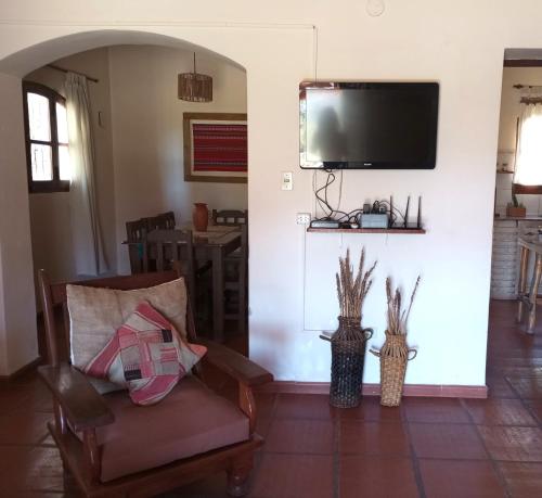 a living room with a chair and a flat screen tv at Casona Inkill Huasi II in Tilcara