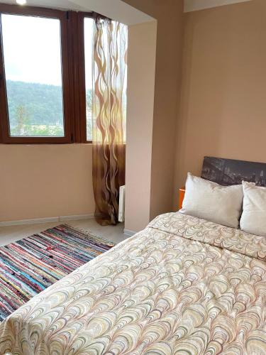 a bedroom with a large bed and a window at Апартамент "Скален венец" in Veliko Tŭrnovo