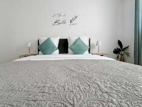 une chambre avec un grand lit avec des oreillers bleus dans l'établissement Cosy Apartment Near Disneyland Paris, à Serris