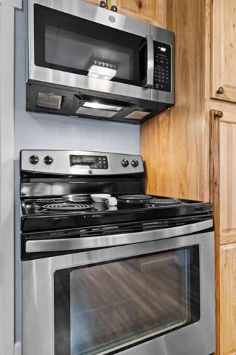 a microwave above a stove in a kitchen at Close to Hiawatha Tr and Biking with HOT TUB in Wallace