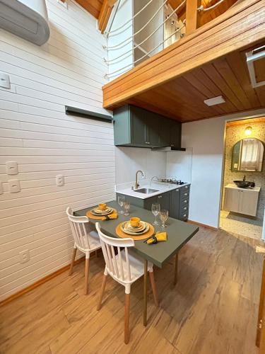 a kitchen with a table and chairs in a kitchen at Winter Hut - Tiny House Village in São Joaquim