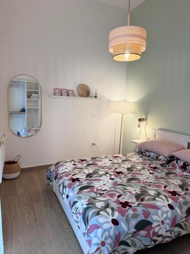 a bedroom with a bed and a lamp and a mirror at Maison Comì in Frattamaggiore