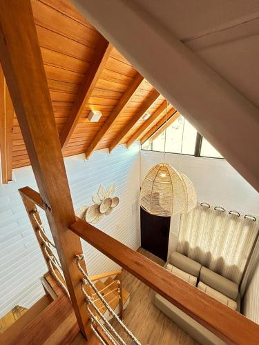 an attic room with a couch and a chandelier at Winter Hut - Tiny House Village in São Joaquim
