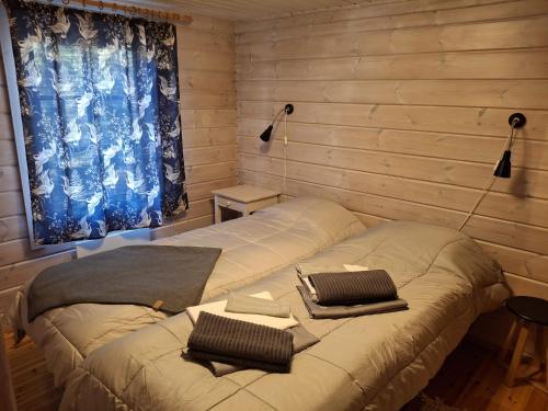 a bed in a room with two pillows on it at Hillatupa in Kolari