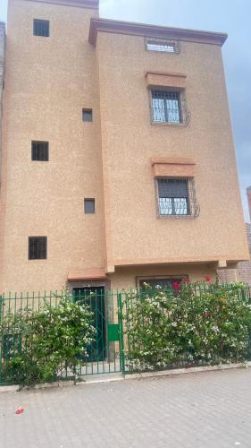a large building with two windows and a fence at Aéroport studio Marrakech in Marrakech