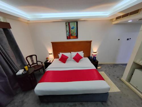 a bedroom with a large bed with red pillows at Le Paradise Palace Hotel Deira Dubai Al Rigga in Dubai
