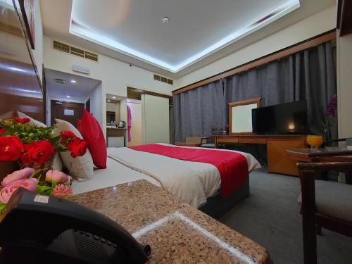 a hotel room with a bed and a flat screen tv at Le Paradise Palace Hotel Deira Dubai Al Rigga in Dubai