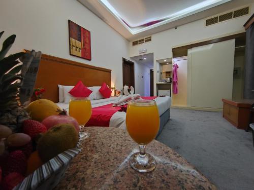 a hotel room with two glasses of orange juice on a table at Le Paradise Palace Hotel Deira Dubai Al Rigga in Dubai