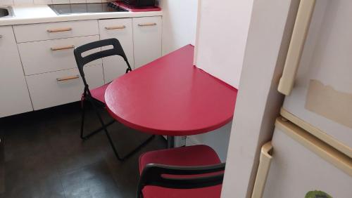 une table rouge et une chaise dans une cuisine dans l'établissement Apartment with a superb view on Eiffel Tower, à Issy-les-Moulineaux
