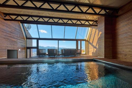 - une piscine dans une maison avec une grande fenêtre dans l'établissement Hôtel Le Grand Tétras, à Font-Romeu