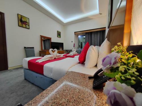 a hotel room with a large bed and flowers at Le Paradise Palace Hotel Deira Dubai Al Rigga in Dubai