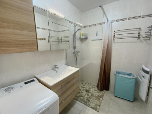 une salle de bain blanche avec un lavabo et un miroir dans l'établissement La terrasse au bord du Lac, vue panoramique lac et montagnes , 2 ch, linge et ménage inclus, à Savines