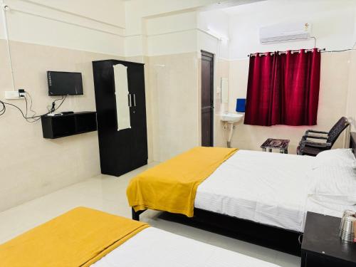 a hotel room with two beds and a red curtain at MSResidency in Golden Rock