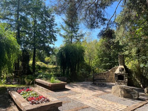 a garden with some flowers and a stone fireplace at Las i Staw Roztocze in Wólka Łosiniecka
