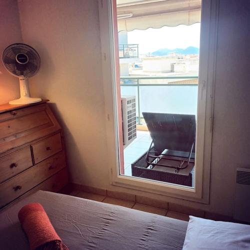 une chambre avec un lit et une fenêtre avec vue dans l'établissement Apt calme 2 chambres vue dégagée, à Cannes