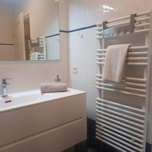 une salle de bain blanche avec un lavabo et un miroir dans l'établissement Apt calme 2 chambres vue dégagée, à Cannes