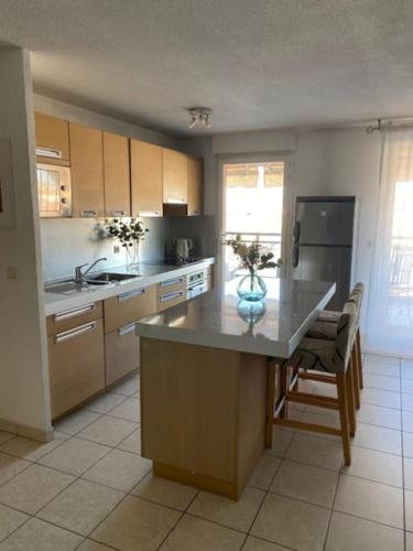 - une cuisine avec un îlot au milieu d'une pièce dans l'établissement Apt calme 2 chambres vue dégagée, à Cannes