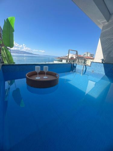 a swimming pool with two wine glasses on top of it at DREAM HOTEL SARANDA in Sarandë